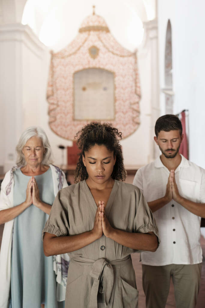 Family praying together at home while connecting through a digital faith platform for spiritual growth and devotion