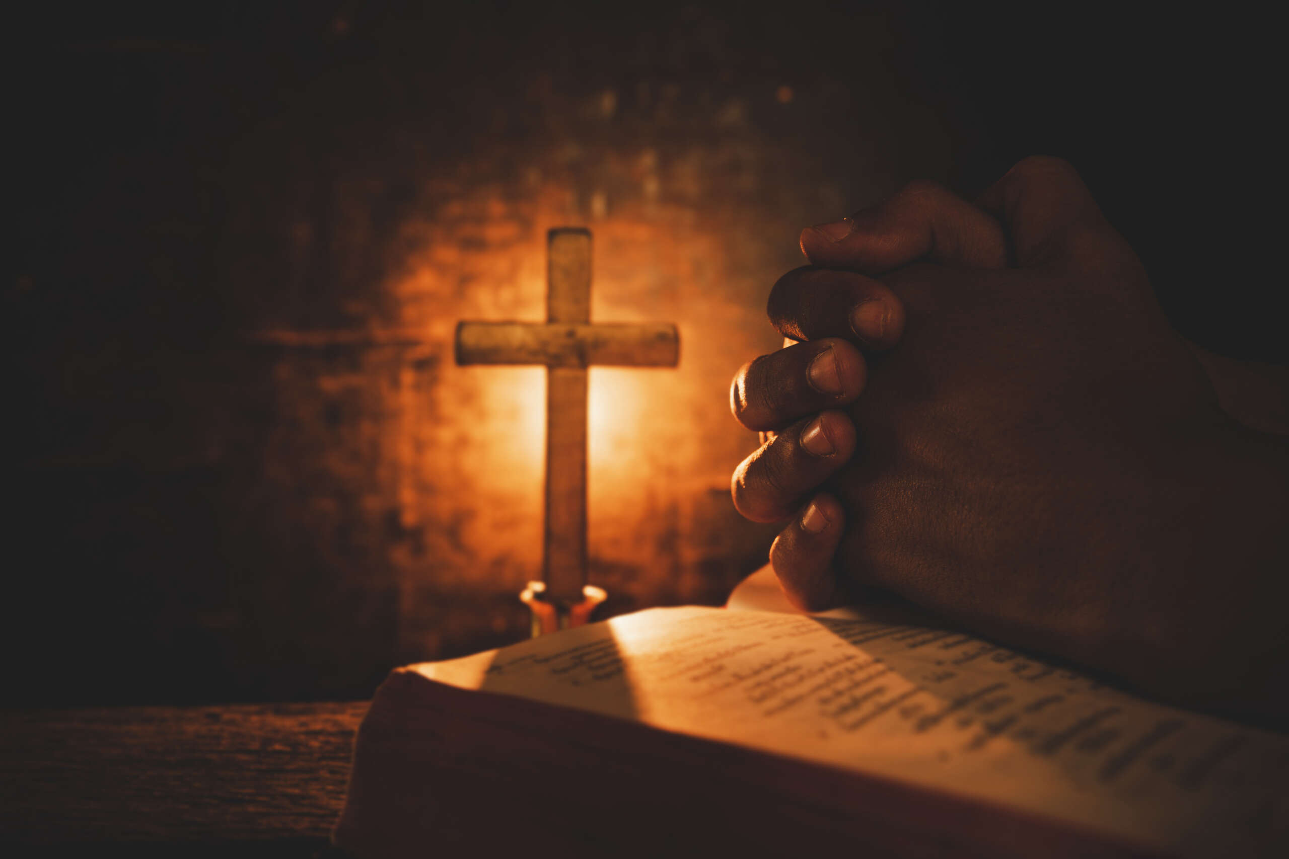 Vintage photo of hand with Bible praying , Hands folded in prayer on a Holy Bible , Spirituality and Religion Concept
