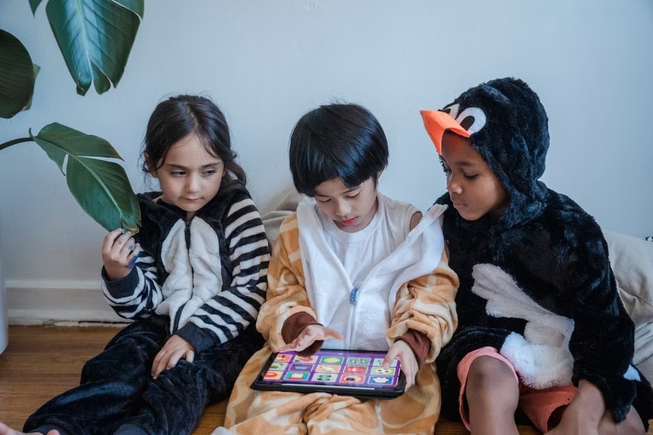 Children using a app together for daily prayer, devotion, and spiritual growth at home
