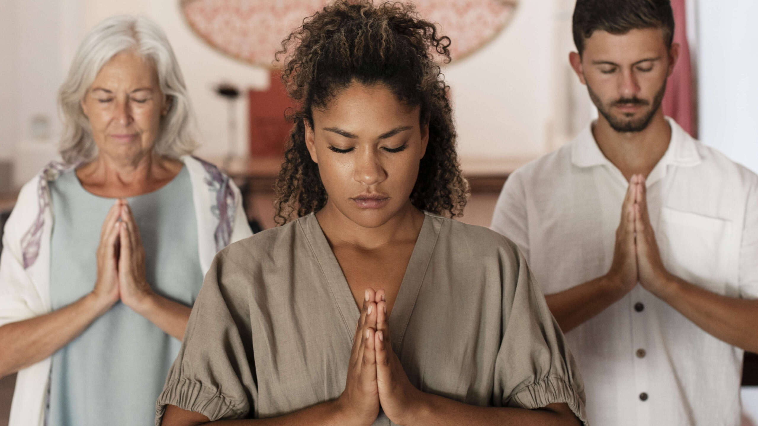Family praying together at home while connecting through a digital faith platform for spiritual growth and devotion