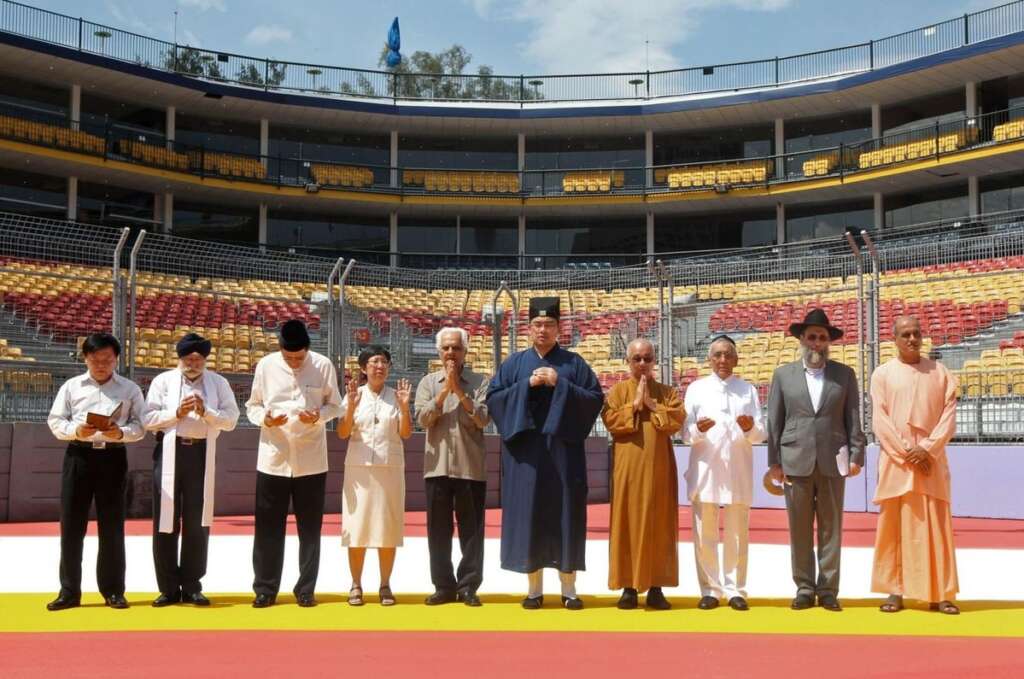 Diverse group of people from various faith backgrounds standing together in shared prayer and community