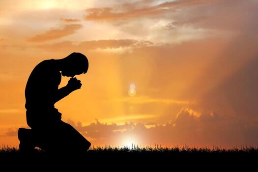 Person holding a smartphone in a dimly lit room engaging in quiet anonymous prayer and reflection